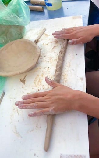 Teen student sculpting with clay